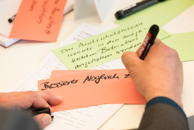 Ein Workshop-Teilnehmer beschreibt Karten für die Pinnwand. Ein Workshop-Teilnehmer beschreibt Karten für die Pinnwand.