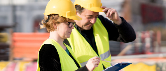Beschäftigte am Bau mit Helmen und Warnwesten (verweist auf: Handlungshilfen und Empfehlungen für den betrieblichen Arbeitsschutz)