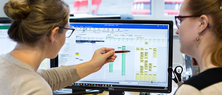 Zwei Frauen stimmen Terminkalender am PC ab. Zwei Frauen stimmen Terminkalender am PC ab.