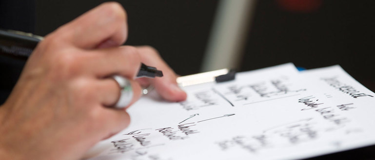 Hand mit Stift auf Notitzblock Hand mit Stift auf Notitzblock