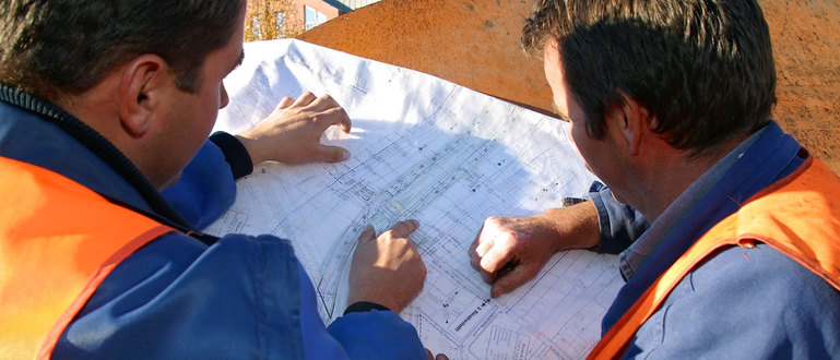 Zwei Bauarbeiter studieren Bauplan.