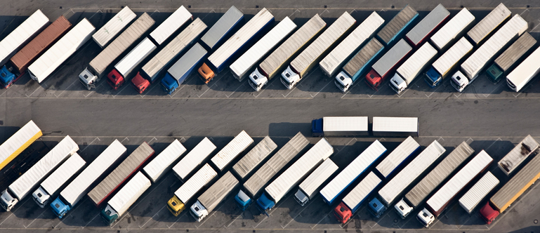 Luftaufnahme: Parkplatz mit vielen Lastkraftwagen